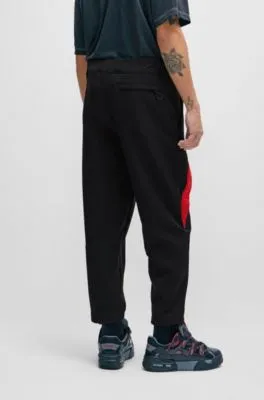 Relaxed-fit tracksuit bottoms with red logo tape